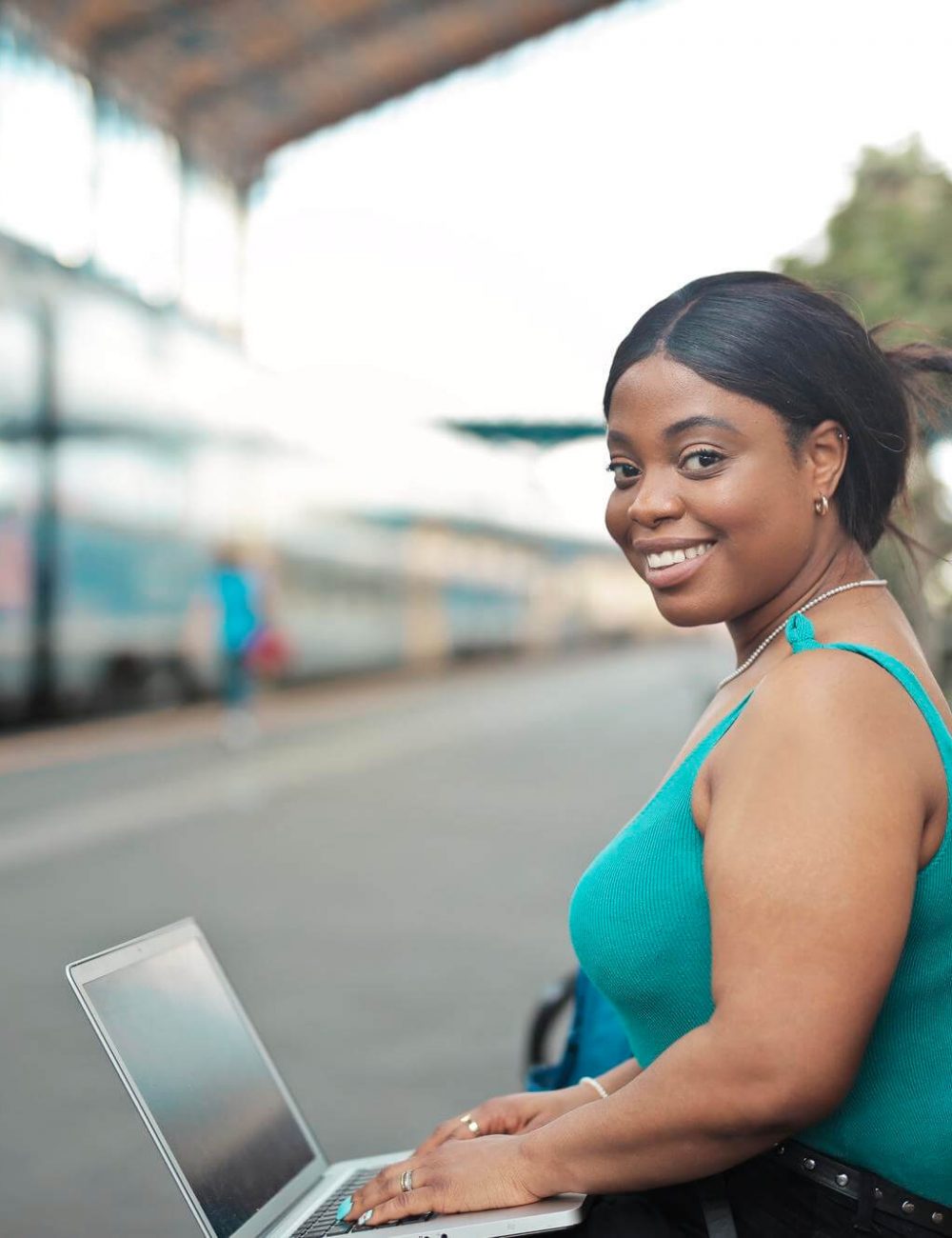 portrait-of-young-woman-with-laptop-in-train-station